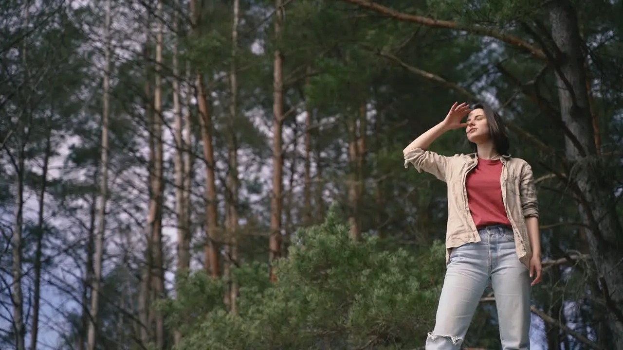 A Pretty Brunette Girl Looks Out Over The Horizon In The Forest