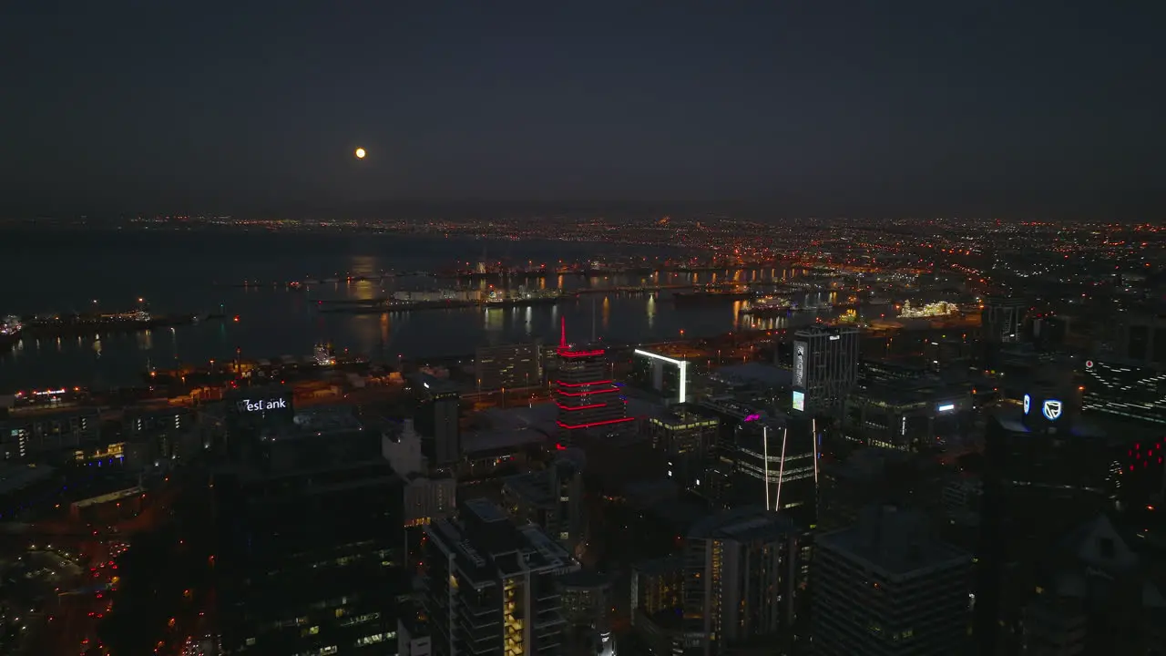 Aerial descending footage of city centre and large seaport at night Illuminated buildings and street lights Cape Town South Africa