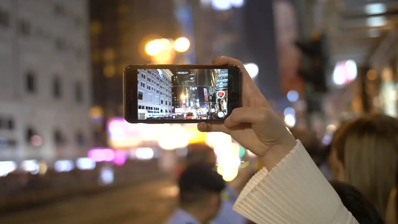 Person Filming Parade on Smartphone