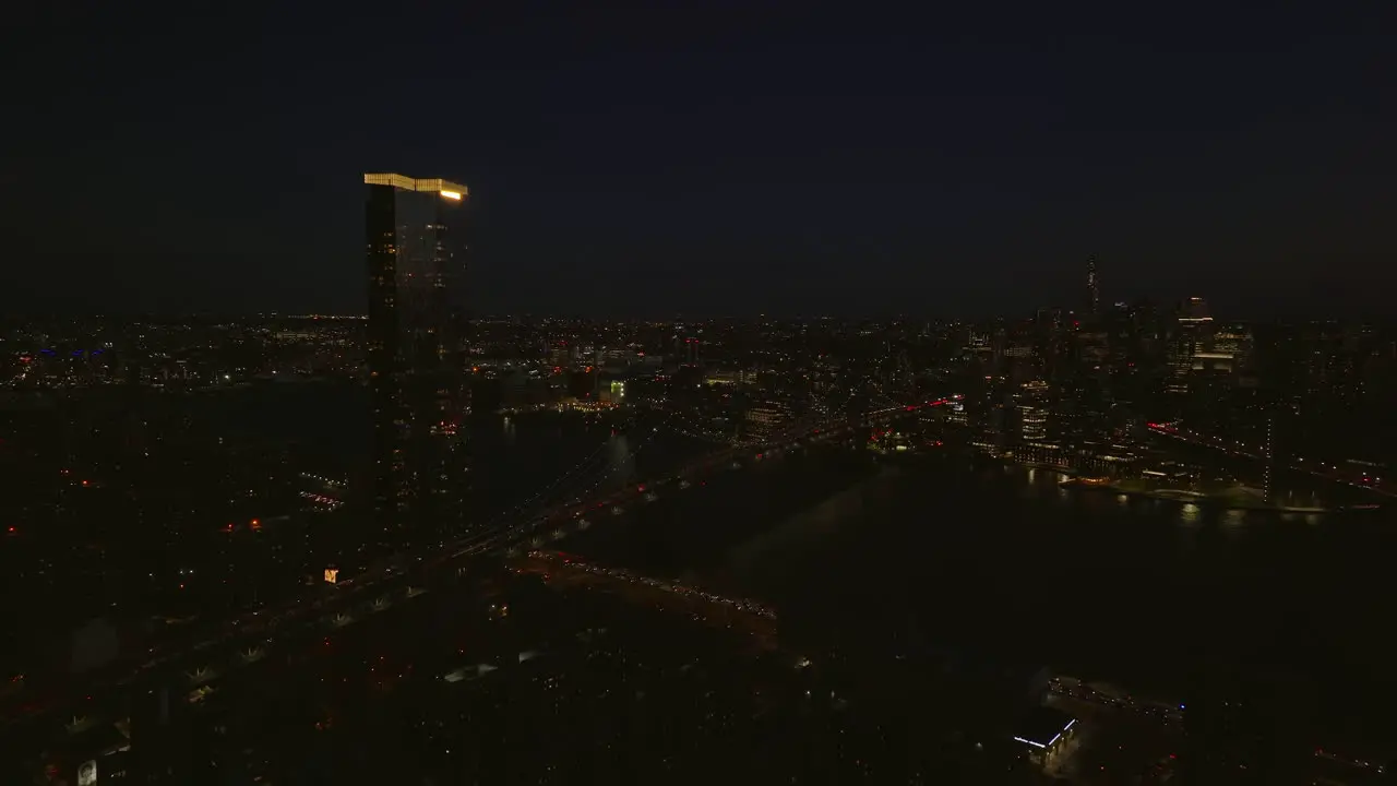 Aerial panoramic night shot of One Manhattan Square apartment building with illuminated rooftop and busy road on Manhattan bridge to Brooklyn Manhattan New York City USA