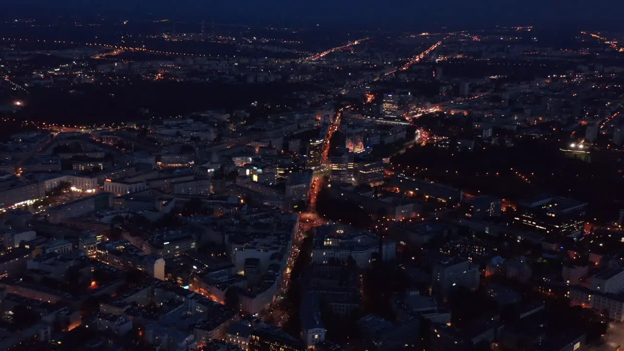 Aerial panoramic shot of night city Illuminated streets ad buildings in urban neighbourhood Warsaw Poland