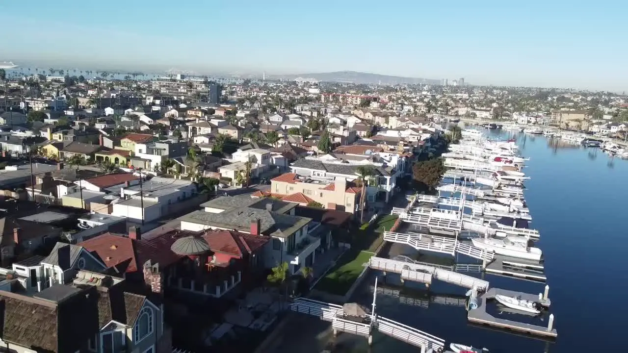 Fly over houses with boat docks bridge and rowboat drone shot