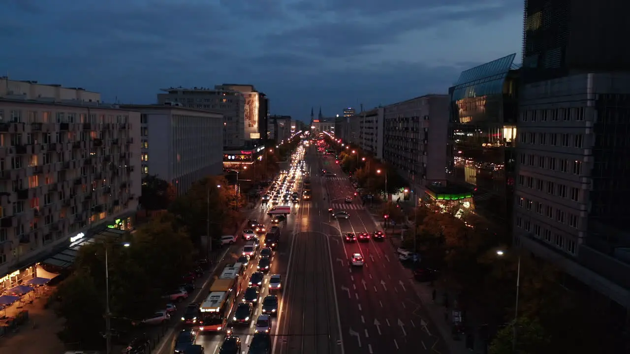 Forwards reveal of wide street with heavy evening traffic Multilane boulevard in city centre with crosswalks and crossroads Warsaw Poland