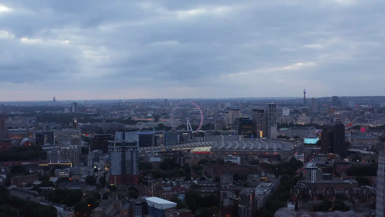 Panoramic view of cityscape at dusk Waterloo train station and London Eye tourist attraction London UK