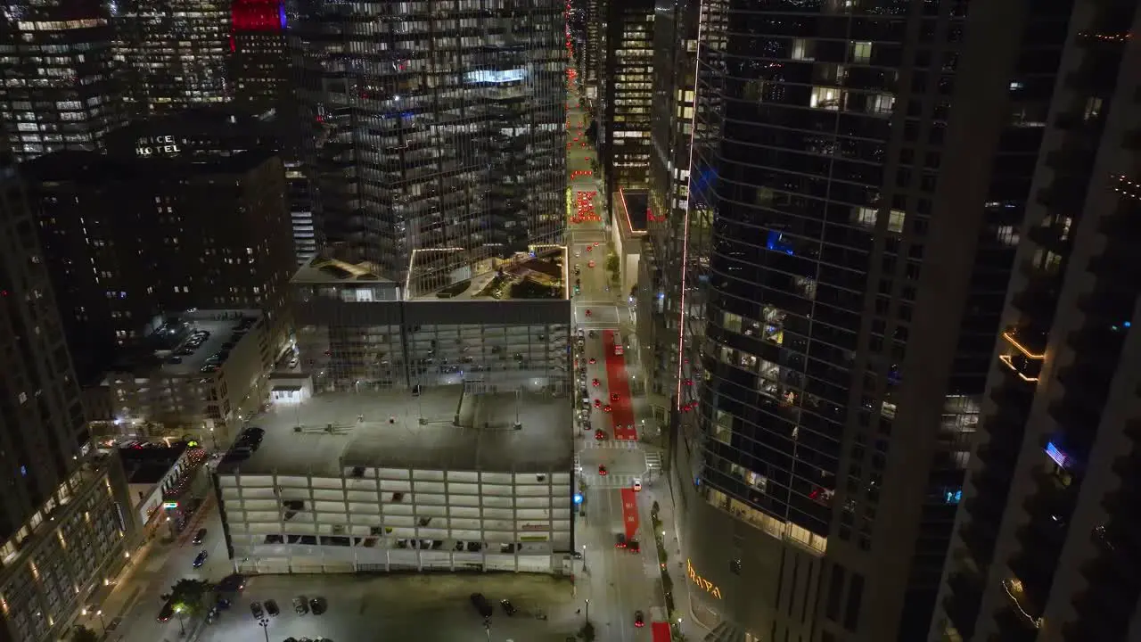 Aerial view of traffic in middle of high-rise in Houston evening in Texas USA reverse drone shot