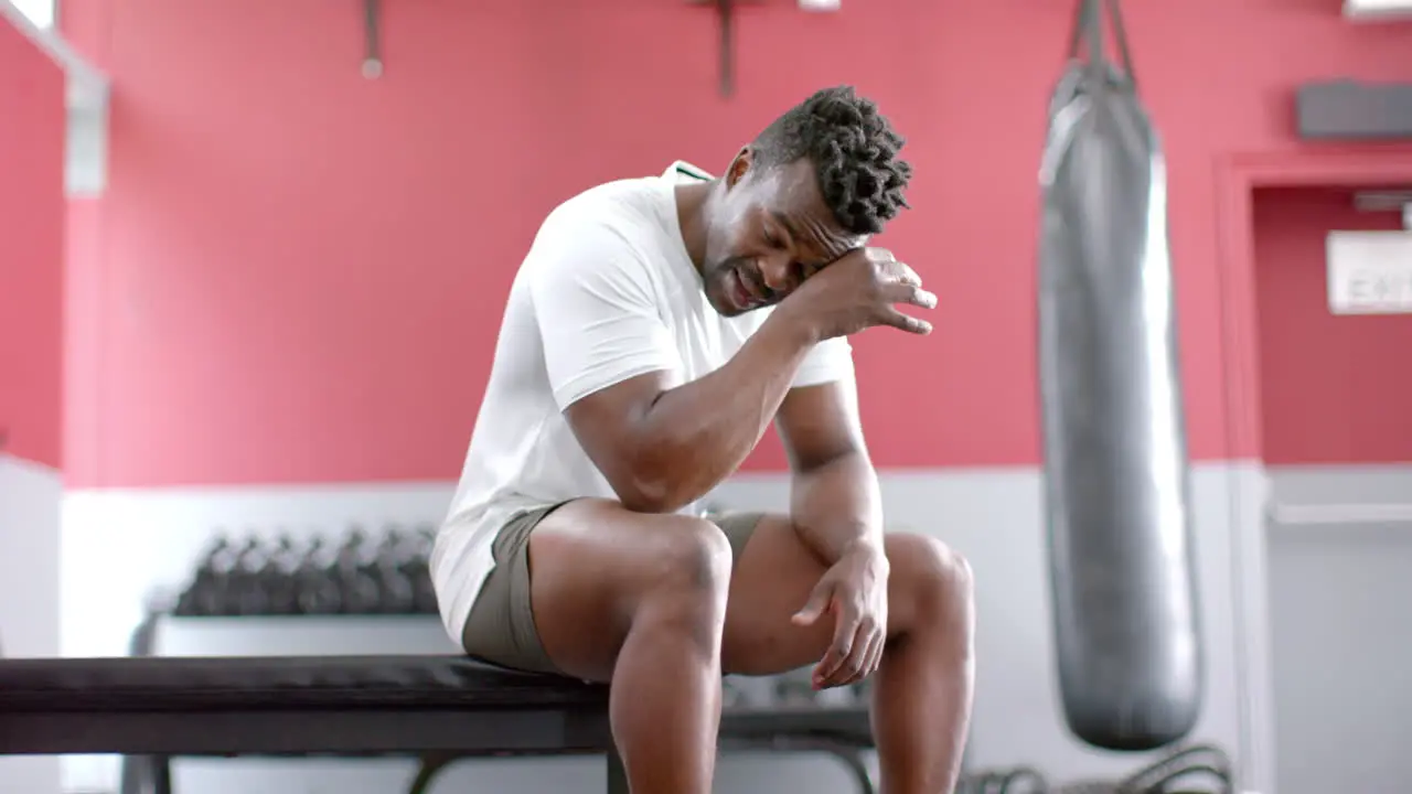 Fit African American man looks exhausted at the gym