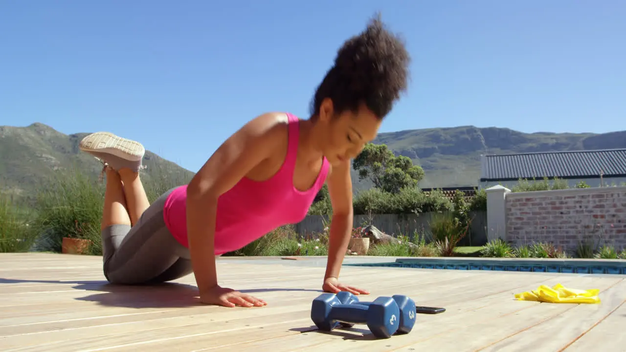 Mixed-race young woman doing exercise in the backyard of their home 4k