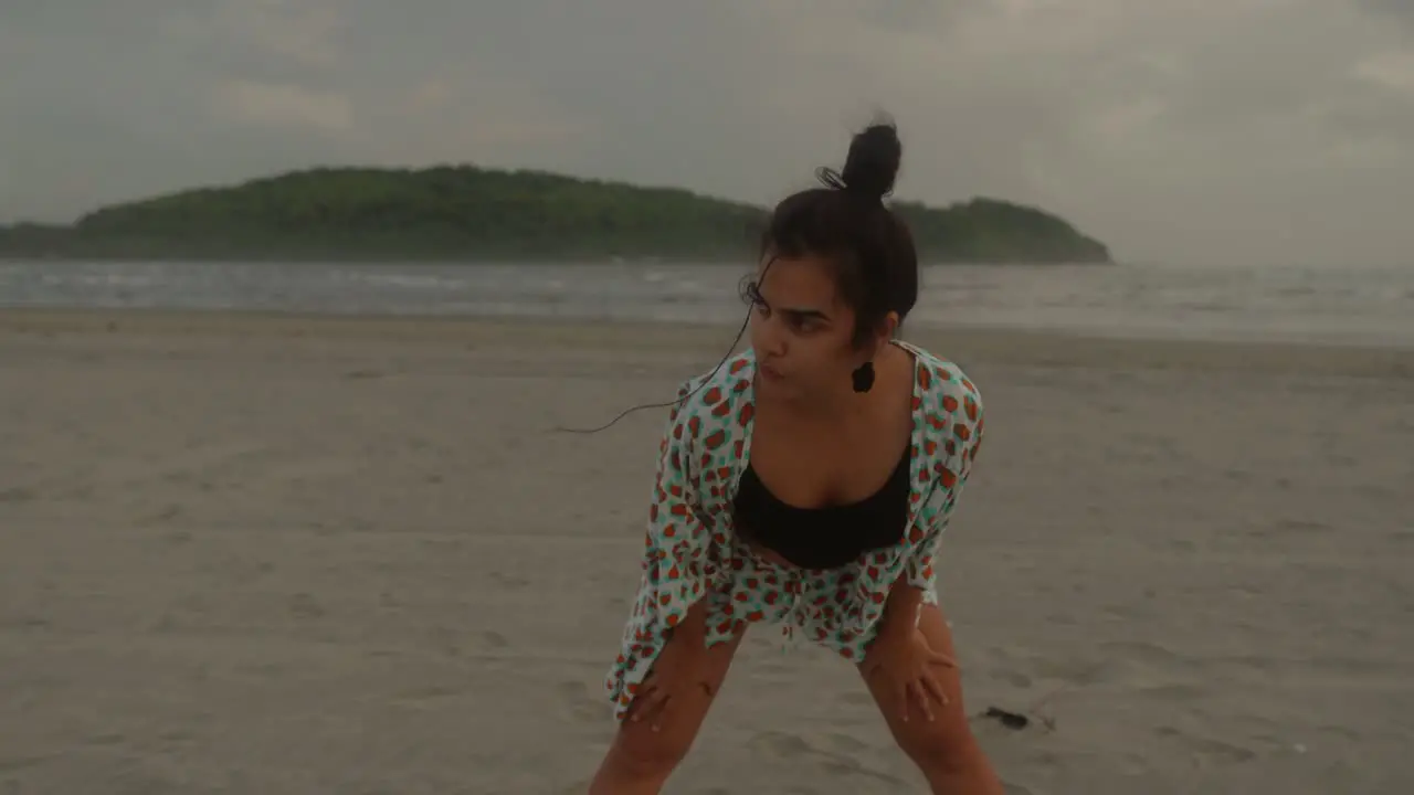 Middle shot of an Indian woman practicing yoga on the picturesque beach