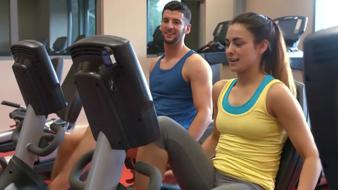 Couple using exercise bikes in gym