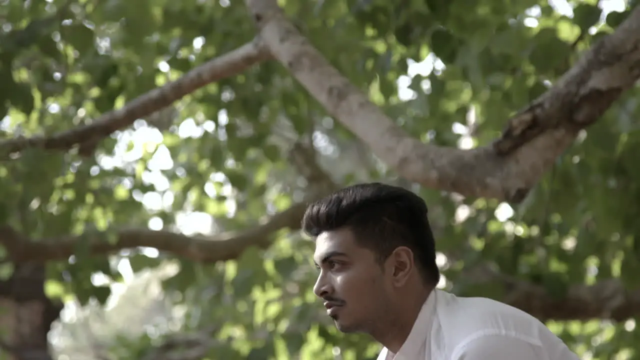 Young handsome Indian man does yoga in front of temples