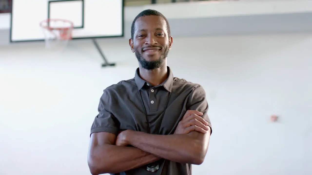 Confident African American coach stands in a gym