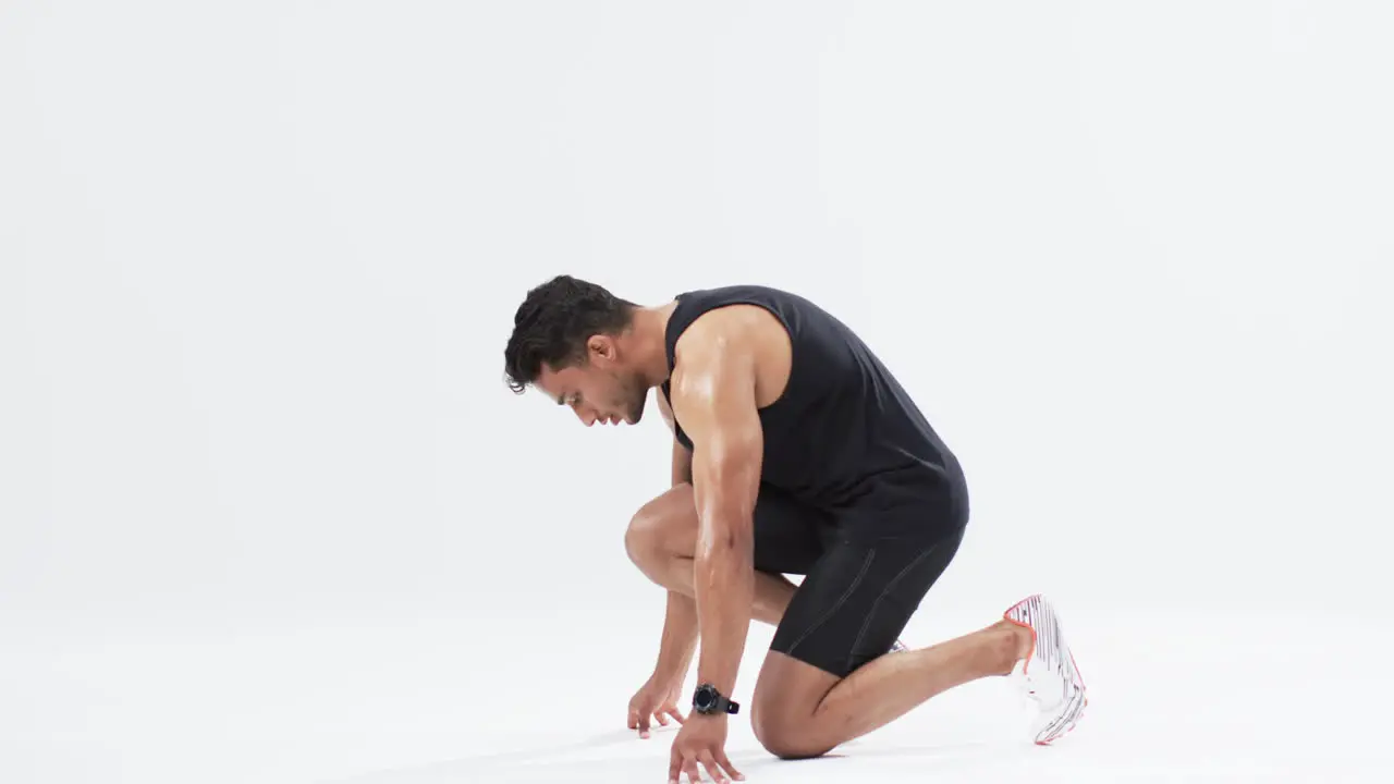 Athlete in starting position ready to sprint with copy space on white background