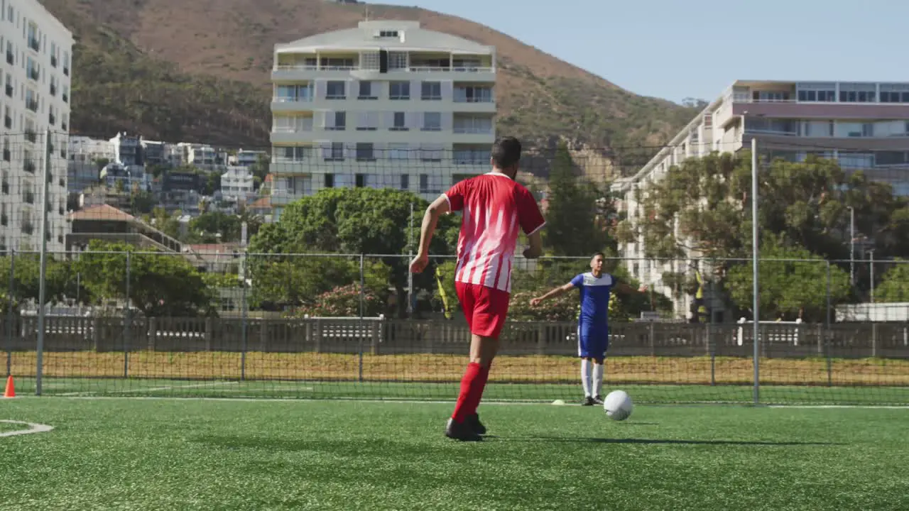 Animation of social media icons over biracial male soccer player dribbling on sports field