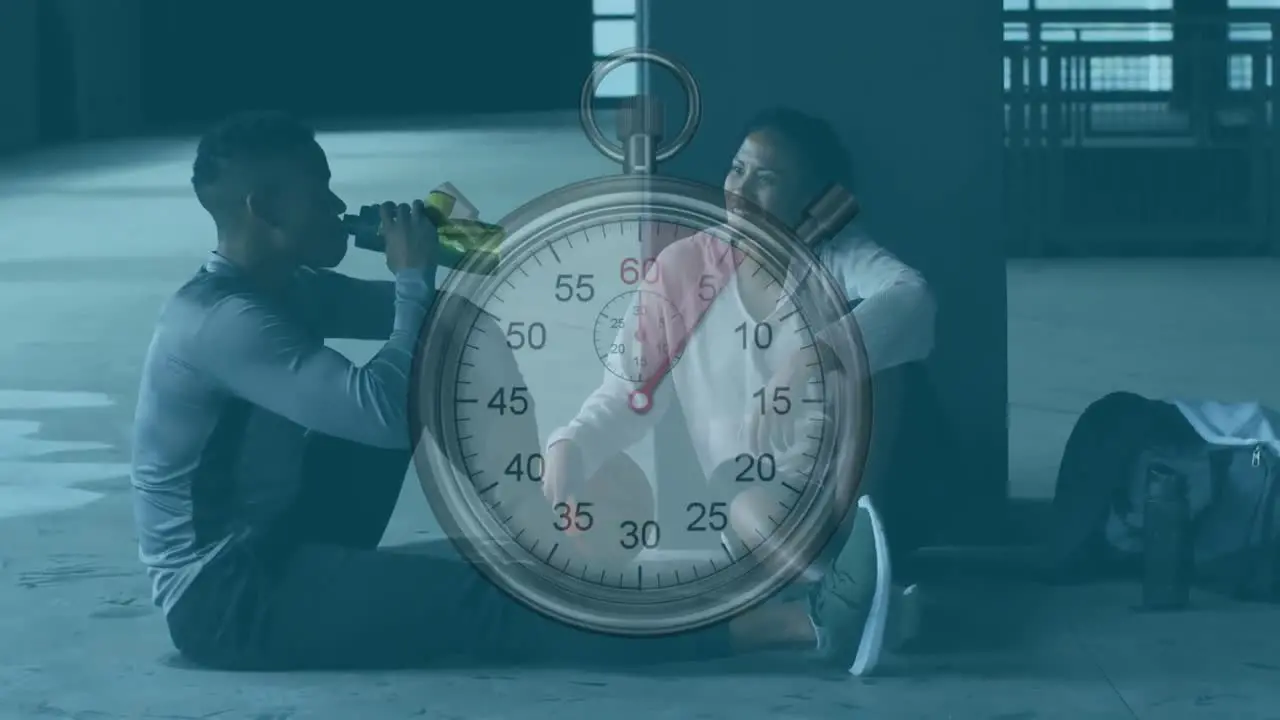 Stopwatch against african american man and woman taking a break from working out