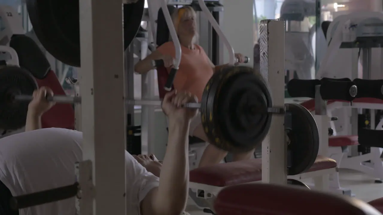 Two senior people training on fitness machines