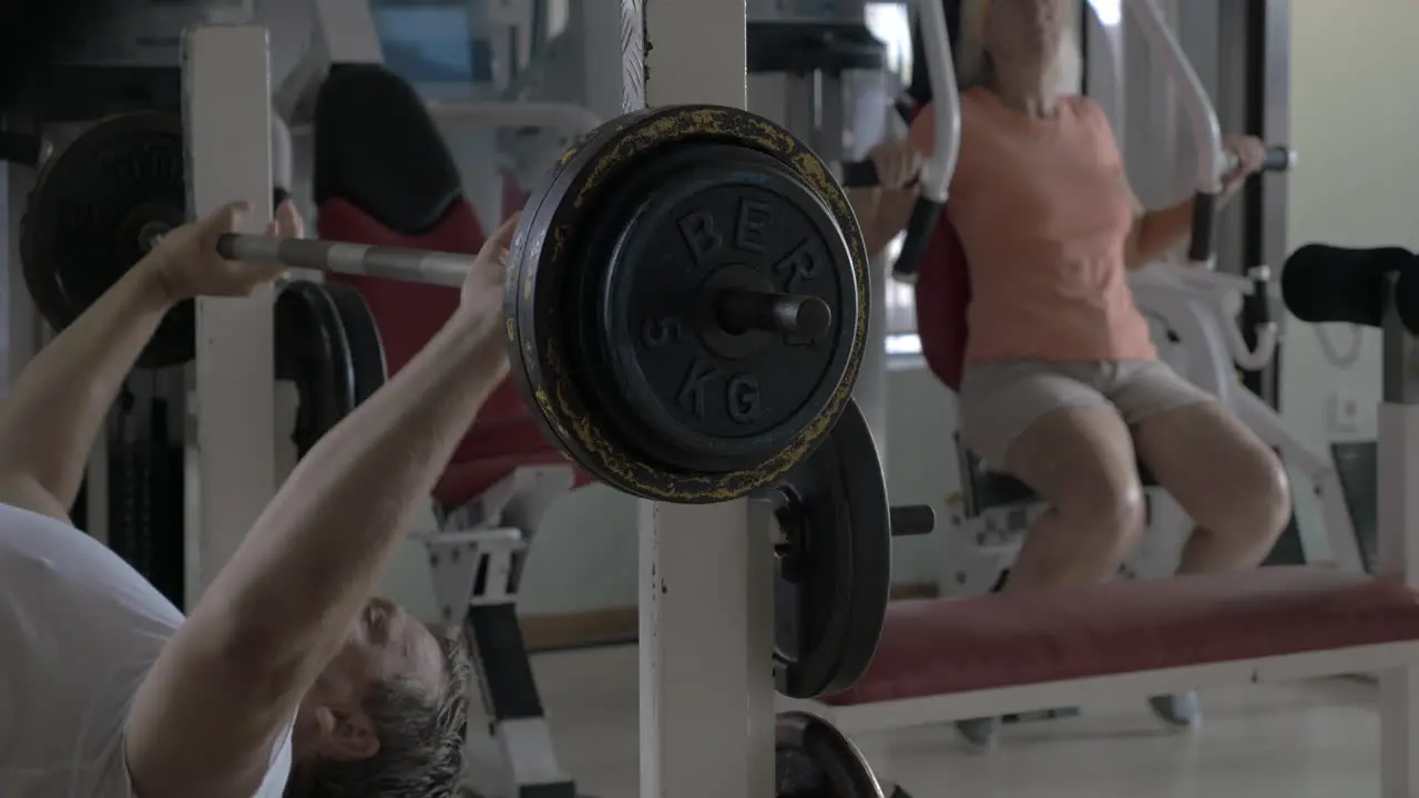 Senior man and woman working out in the gym