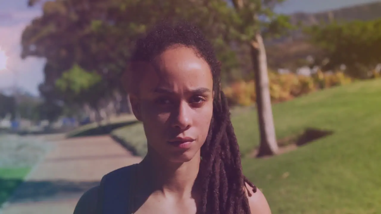 Spots of light against close up of african american woman in the park