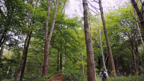 Slow Motion Shot Of Man On Mountain Bike Making Mid Air Jump On Dirt Trail Through Woodland 13