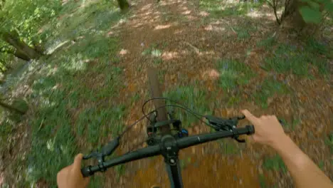 POV Shot Of Man On Mountain Bike Doing Mid-Air Jumps On Trail Through Woodland 3 