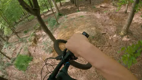 POV Shot Of Man On Mountain Bike Doing Mid-Air Jumps On Trail Through Woodland 5