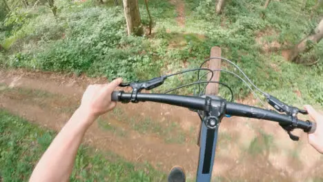 POV Shot Of Man On Mountain Bike Doing Mid-Air Jumps On Trail Through Woodland 2