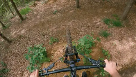 POV Shot Of Man On Mountain Bike Doing Mid-Air Jumps On Trail Through Woodland 4