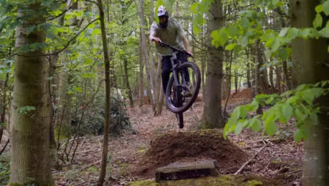 Slow Motion Shot Of Man On Mountain Bike Making Mid Air Jump On Dirt Trail Through Woodland 6