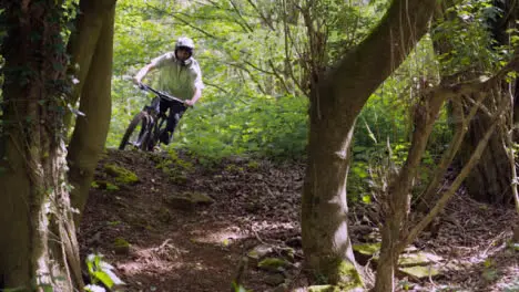 Slow Motion Shot Of Man On Mountain Bike Making Mid Air Jump On Dirt Trail Through Woodland 10