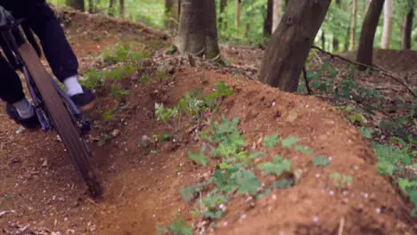 Slow Motion Shot Of Man On Mountain Bike Making Mid Air Jump On Dirt Trail Through Woodland 12