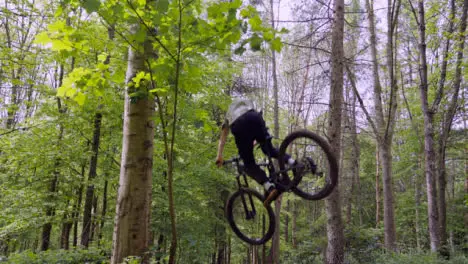 Slow Motion Shot Of Man On Mountain Bike Making Mid Air Jumps On Dirt Trail Through Woodland 6