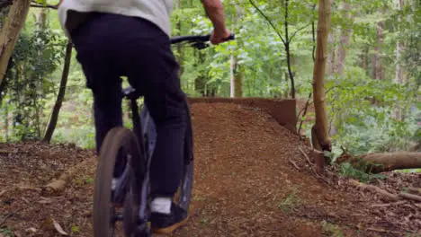 Slow Motion Shot Of Man On Mountain Bike Making Mid Air Jumps On Dirt Trail Through Woodland 5