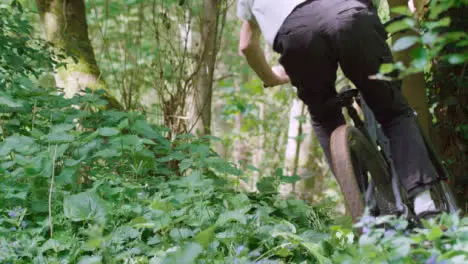 Slow Motion Shot Of Man On Mountain Bike Making Mid Air Jump On Dirt Trail Through Woodland 16