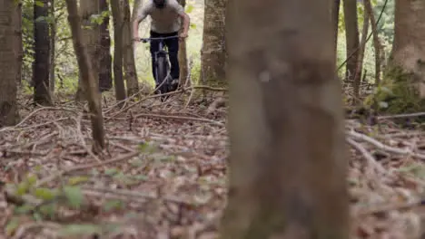 Close Up Rear View Of Young Man On Mountain Bike Cycling Along Trail Through Woodland