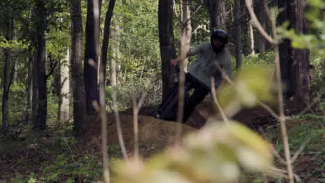 Slow Motion Shot Of Man On Mountain Bike Cycling Along Dirt Trail Through Woodland 2