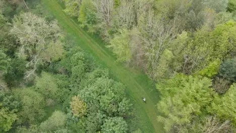 Drone Aerial Shot Of Man On Mountain Bike Cycling Along Trail Through Countryside And Woodland 3