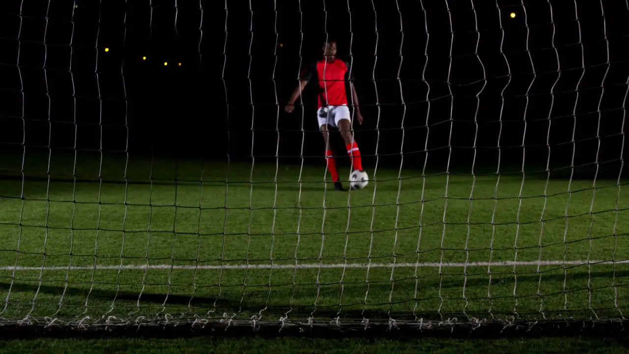 Soccer player scoring a goal against open goal post 4k