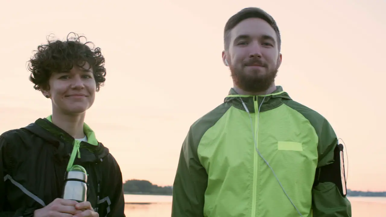 Woman And Man In Sportswear Looking At Camera Outdoors