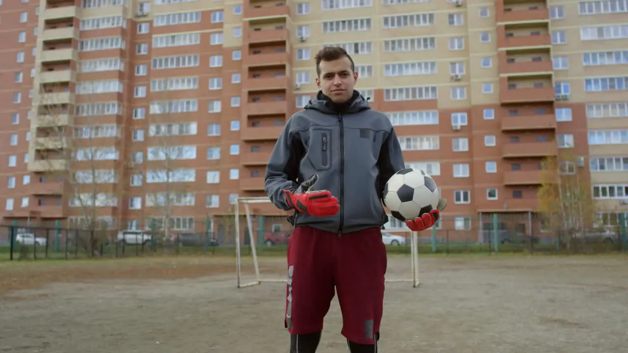 Confident Male Soccer Player With Ball Looking At Camera On The Field