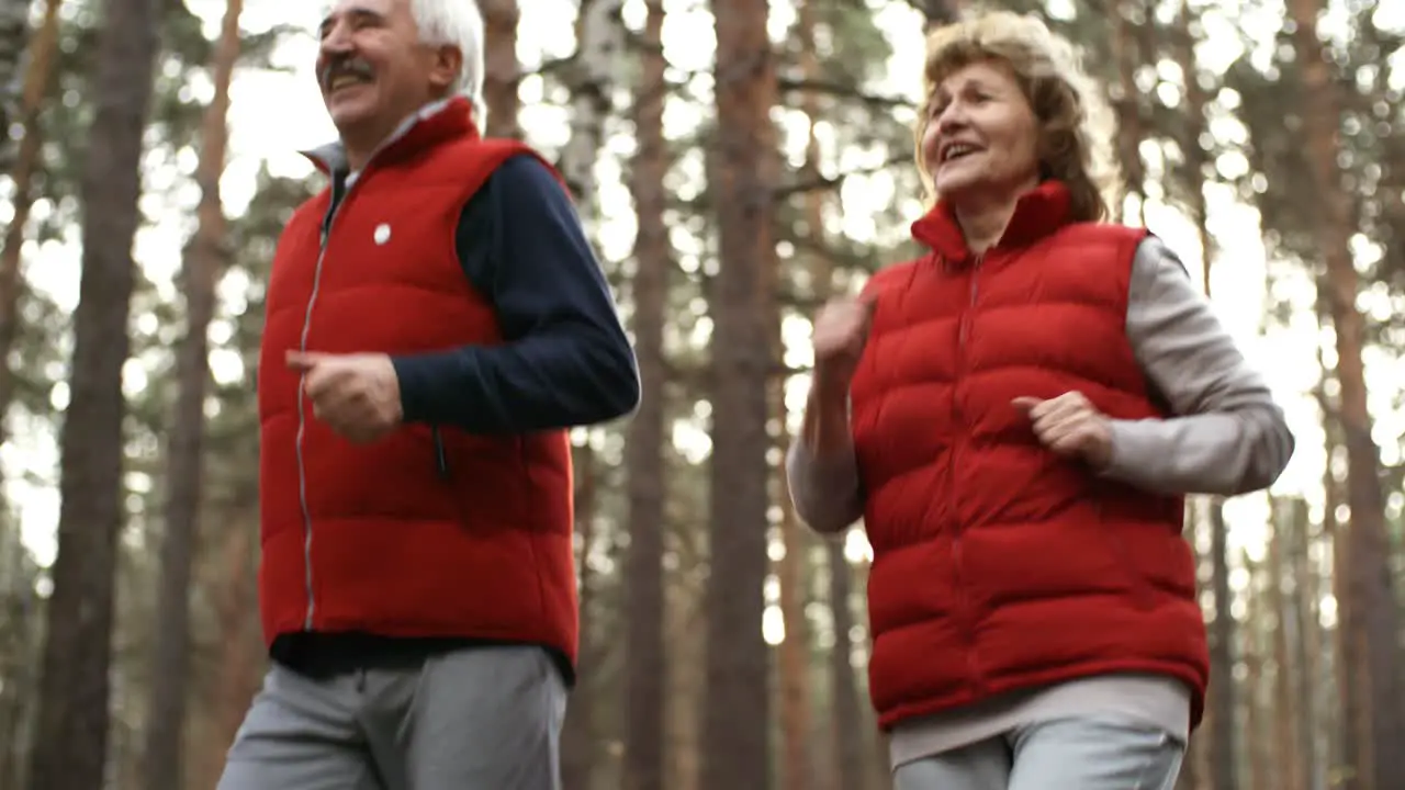 Happy Senior Couple Running Together In The Forest