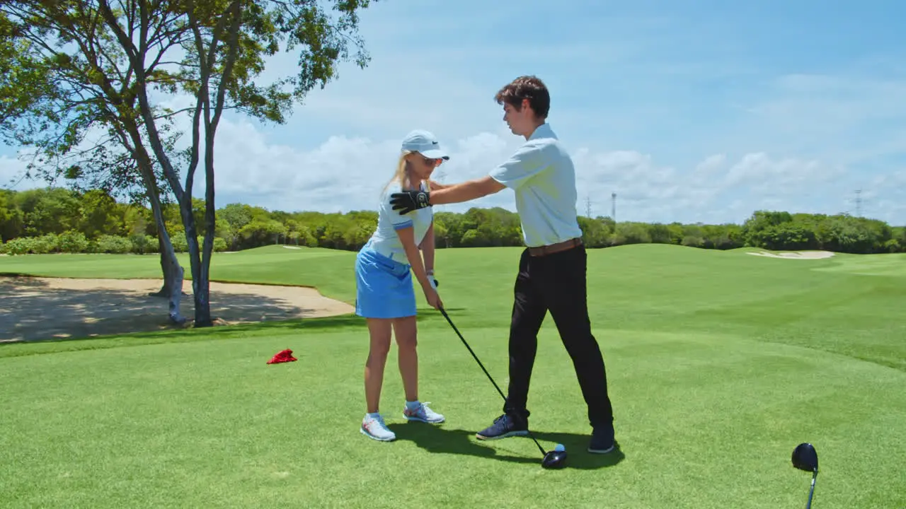 Slow Motion Golf Instructor Teaching Female Student Golf Posture and Correct Handling of Club on Green Course