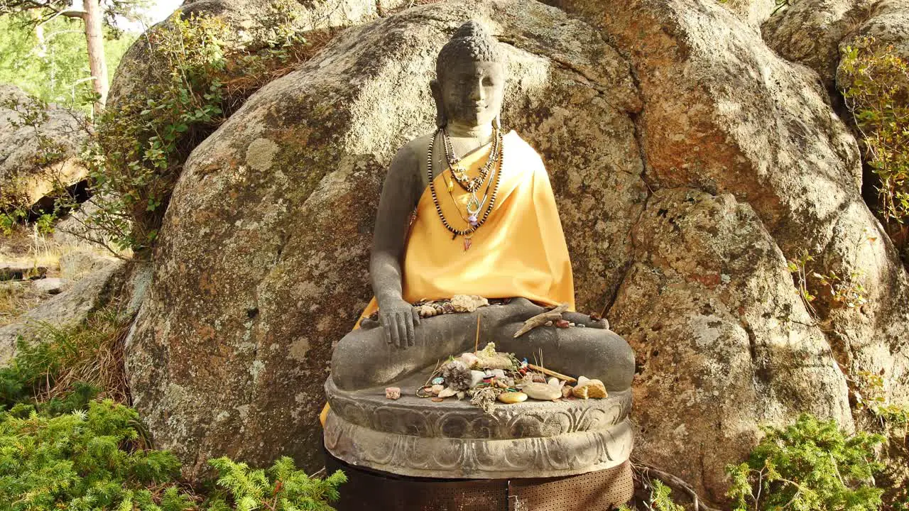 Buddha statue with small offerings around it at the stupa in Red Feather Lakes CO