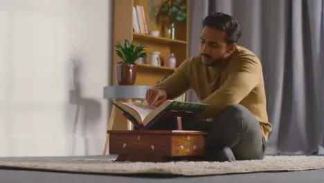 Muslim Man At Home Sitting And Reciting From The Quran 1