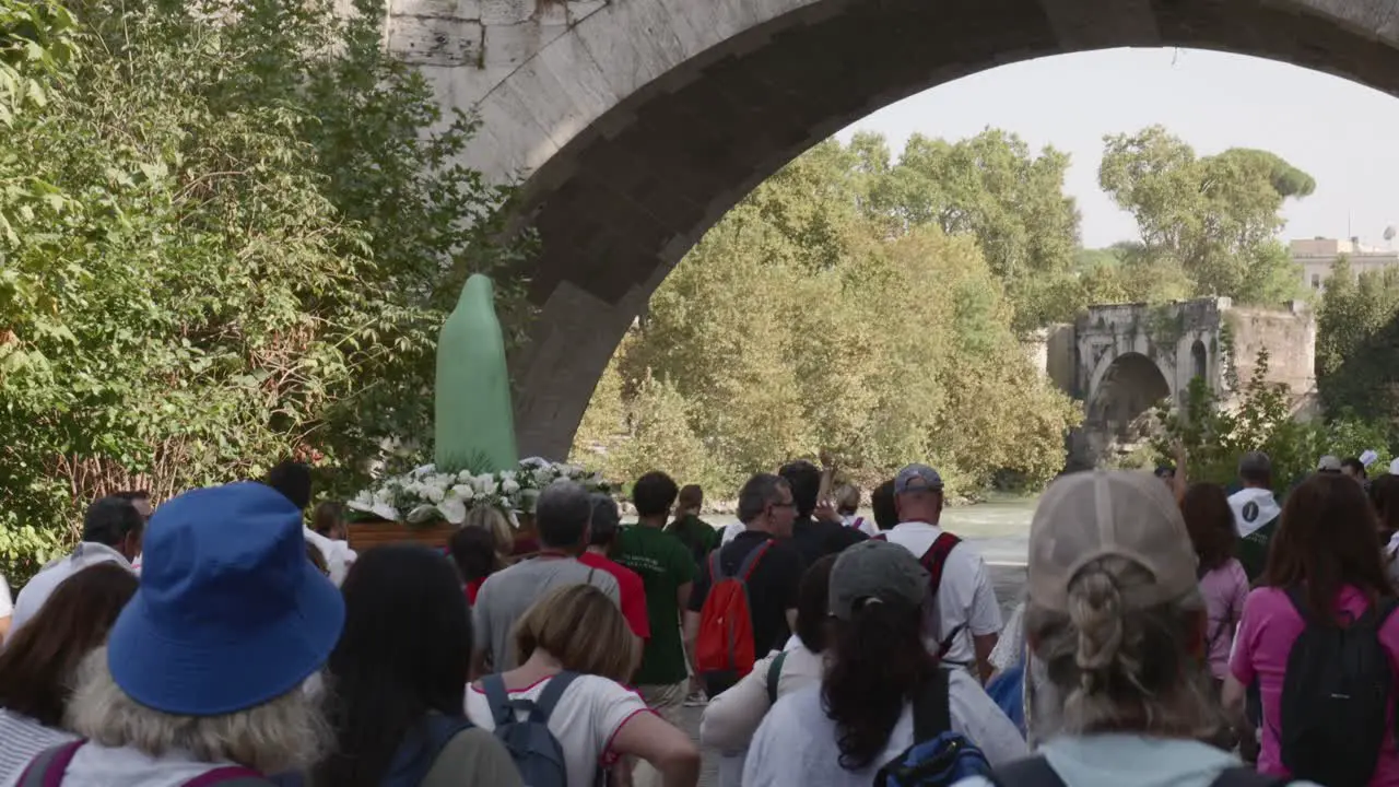 Religious procession in Rome along the banks of Tiber river A statue of the madonna Mary the mother of Jesus Christ is carried by 4 men