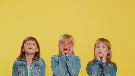 Three girls siblings friends showing thumbs up and pointing empty place advertising promotion area