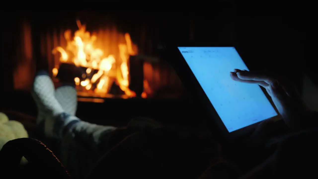 Use A Tablet By The Fireplace In A Cozy Home Environment