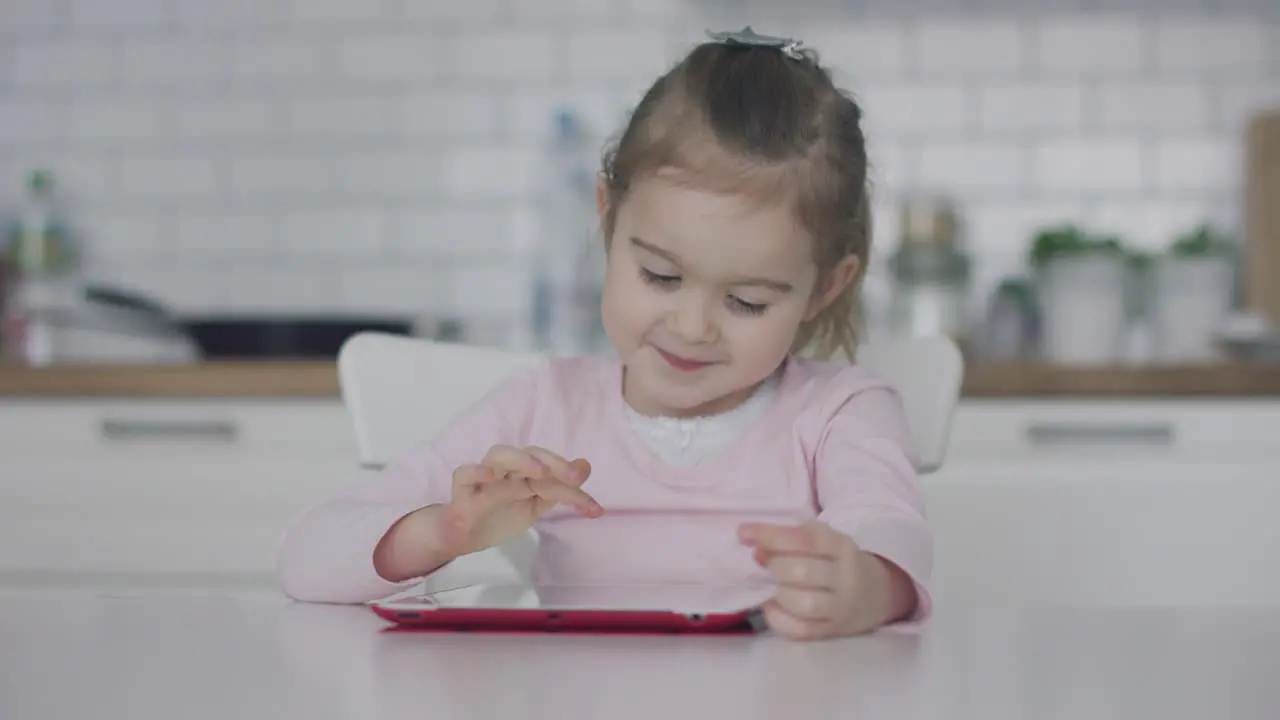 Little girl using tablet in kitchen