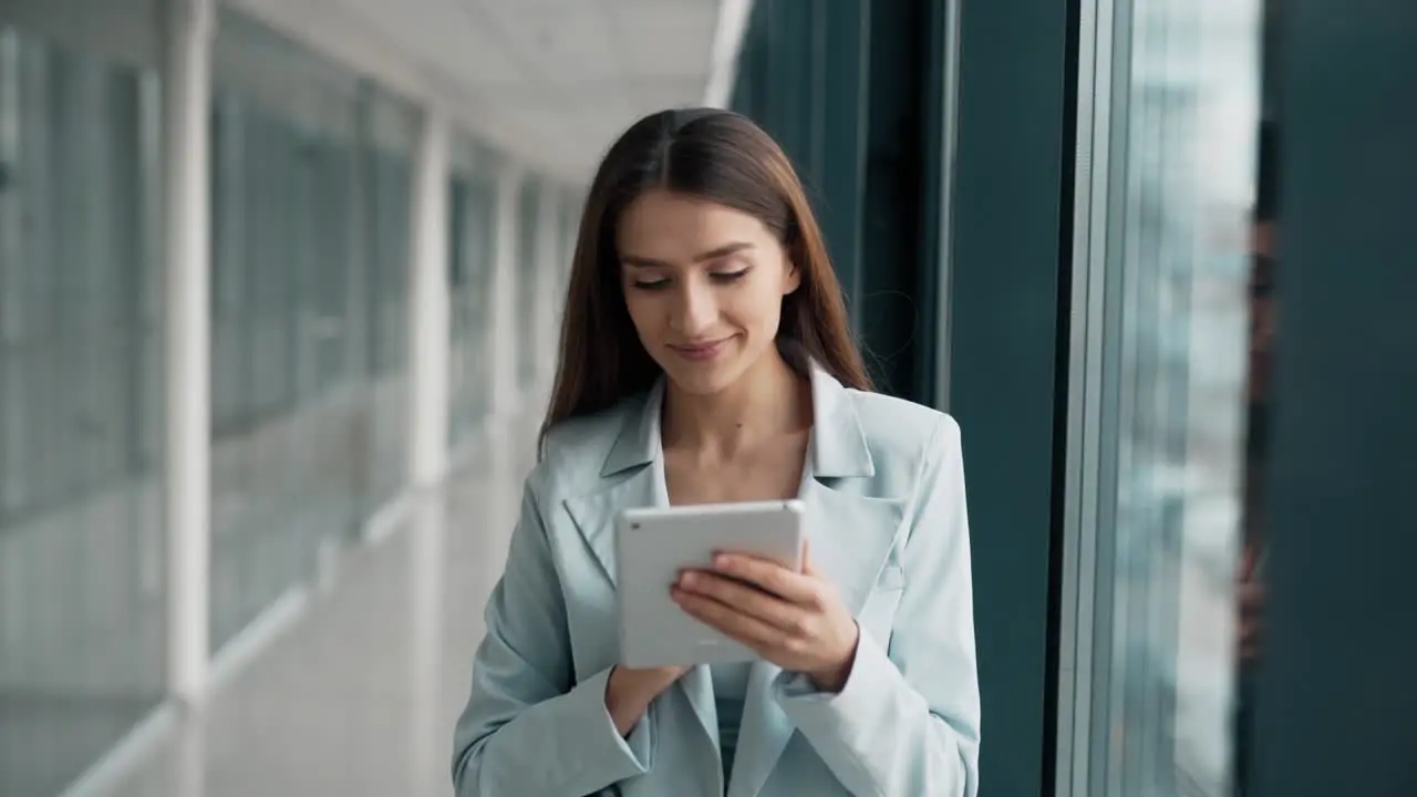 Close-up portrait of a stylish woman in a blue suit with a tablet