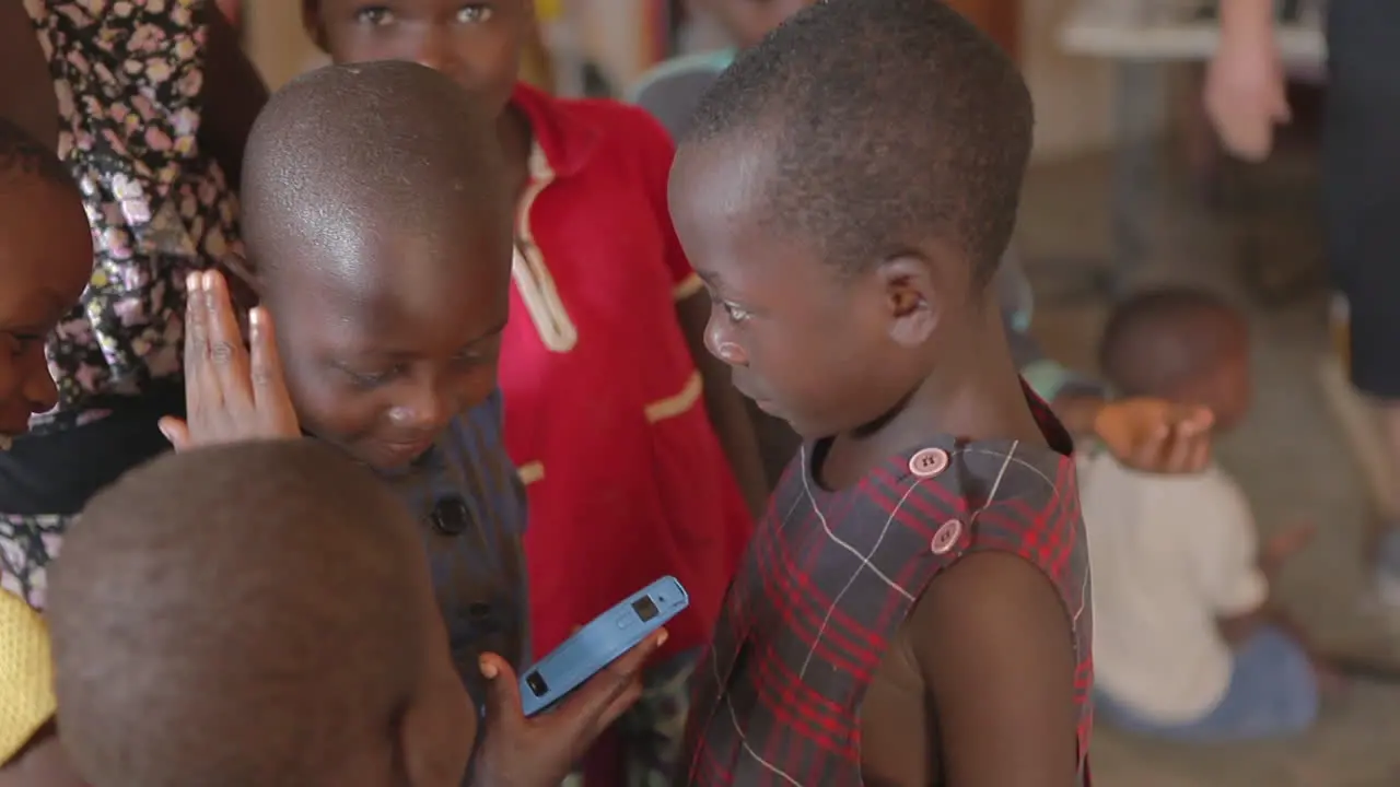 Africa children admire a cell phone 1