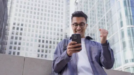 Low Angle Shot of Young Woman On Smartphone Celebrating