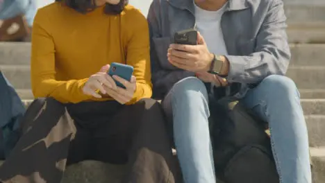 Low Angle Shot of Male Student Showing Female Something on Phone on College Steps